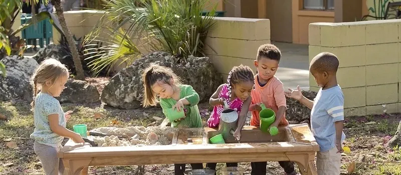 What Are Daycare Space Requirements Per Child? 2 Children Are Playing With Sand On Freestanding Activity Station