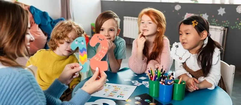 Teacher-To-Child Ratio Guide And How It Shapes Classroom Design 3 Caregiver Sitting With Toddlers In Group Setting